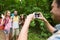 Happy man photographing friends by smartphone