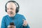 Happy man in portable full-size headphones listens to music using a digital player