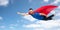 Happy man in red superhero cape flying over sky