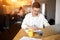 Happy man rejoicing at his successful deal, making notes while having breakfast