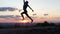 Happy man runs and jumps on a lawn at sunset in slo-mo