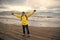 Happy man on sea beach in reykjavik, iceland. Man traveler smile with raised arms on sea shore. Freedom and happiness