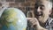 Happy man searching random places on a globe