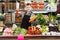 happy man seller showing assortment of grocery shop