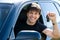 Happy man showing keys in car