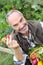 Happy man showing tomatoes from garden