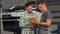 Happy man signing papers after getting his car repaired at service station