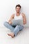 Happy man sitting on floor with laptop