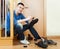 Happy man sitting on stairs and cleaning footwear