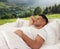 Happy man sleeping in bed and beautiful view of mountain landscape on background. Sleep well - stay healthy