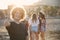 Happy man standing on beach with friends showing thumb up