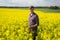 Happy man standing in mustard field