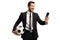 Happy man in a suit holding a soccer ball and looking at a mobile phone