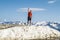 A happy man in summer clothes poses on the highest point of Rosa Peak Mountain in the Sochi resort town of Rosa Khutor