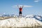 A happy man in summer clothes poses on the highest point of Rosa Peak Mountain in the Sochi resort town of Rosa Khutor