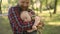 Happy man with toddler in his hands walking outside. Father cheerfully holding baby during walk in the park. Child