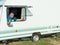 Happy man in a tourist trailer. caravan trailer of large size, ensure the comfort of the traveler. recreational vehicle RV. summer