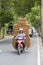 Happy man is transporting goods on a motorbike on a street in Ubud, island Bali, Indonesia, close up