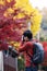 Happy man traveler taking photo colorful leaves in the garden, Asian tourist visit in Kyoto city, Japan and enjoying with