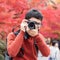 Happy man traveler taking photo colorful leaves in the garden, Asian tourist visit in Kyoto city, Japan and enjoying with