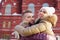 Happy man and woman embrace near red building at