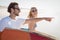 Happy man with woman gesturing while carrying sunrfboard at beach