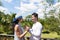 Happy Man And Woman Hodling Hands Stand On Summer Terrace Or Balcony Young Attractive Couple Over Tropical Forest