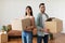 Happy man and woman holding cardboard boxes