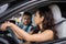 Happy man and woman sitting in the car during summer trip together. Guy looking at lady. Travel adventure drive, happy