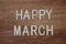 Happy March text message on wooden background