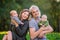 Happy married couple with two little twins resting in nature. Portrait against a background of greenery