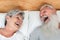 Happy married senior couple having fun lying in bed - Main focus on woman face