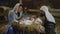 Happy Mary and Joseph with baby Jesus near stalls
