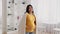 Happy Maternity. Smiling pregnant asian woman covered in plaid tenderly touching belly