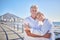 A happy mature caucasian couple enjoying fresh air on vacation at the beach. Smiling retired couple hugging and