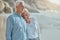 A happy mature caucasian couple enjoying fresh air on vacation at the beach. Smiling retired couple hugging and