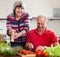 Happy mature couple cooking veggy lunch