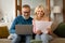 Happy Mature Couple Doing Paperwork And Using Laptop At Home