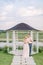 Happy mature couple in elegant clothes, standing near wooden gazebo on the shore of beautiful lake