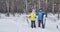 Happy mature couple standing with cross-country skis in snowy forest and smiling