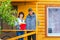 A happy mature couple is standing on the porch of a new wooden house
