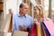 Happy mature family holding bags after shopping