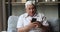 Happy mature grandfather make videocall to beloved grandchildren on smartphone