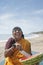 Happy mature Indian woman cutting watermelon at Vagator Beach