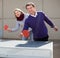 Happy mature man and a woman playing table tennis