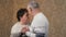Happy mature married couple dancing at home in room, laughing and talking. Beautiful romantic elderly middle-aged