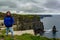 Happy mature Mexican woman on the Cliffs of Moher and the Branaunmore sea stack in the background