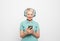 Happy mature short haired woman smiling broadly posing against whte grey background in wireless headphones