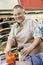 Happy mature store clerk using barcode reader at checkout counter