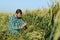 Happy mature technician checking the growth of the wheat for a quality control in a cereal field in summer